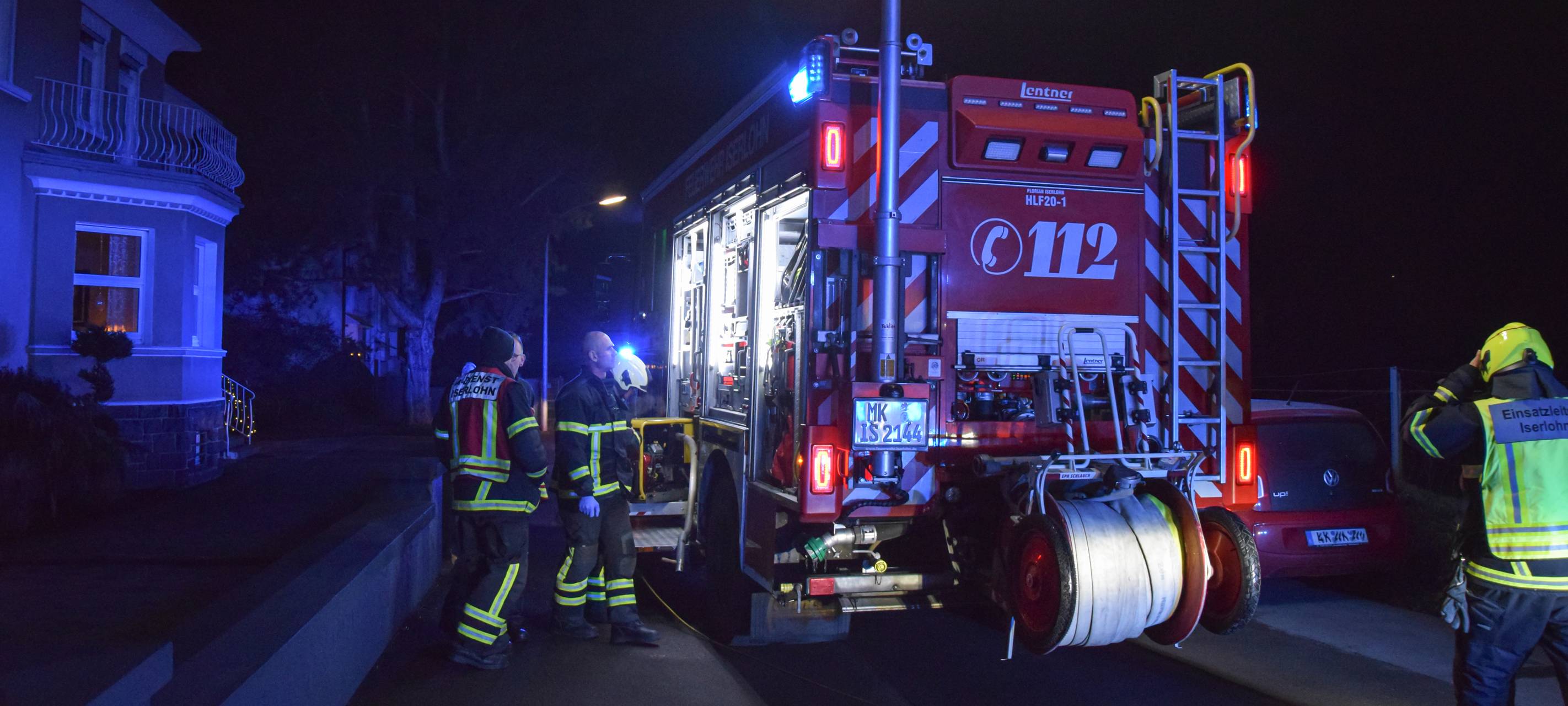 Das Bild zeigt einen Rettungswagen im Dunklen. Drumherum stehen Feuerwehrleute.